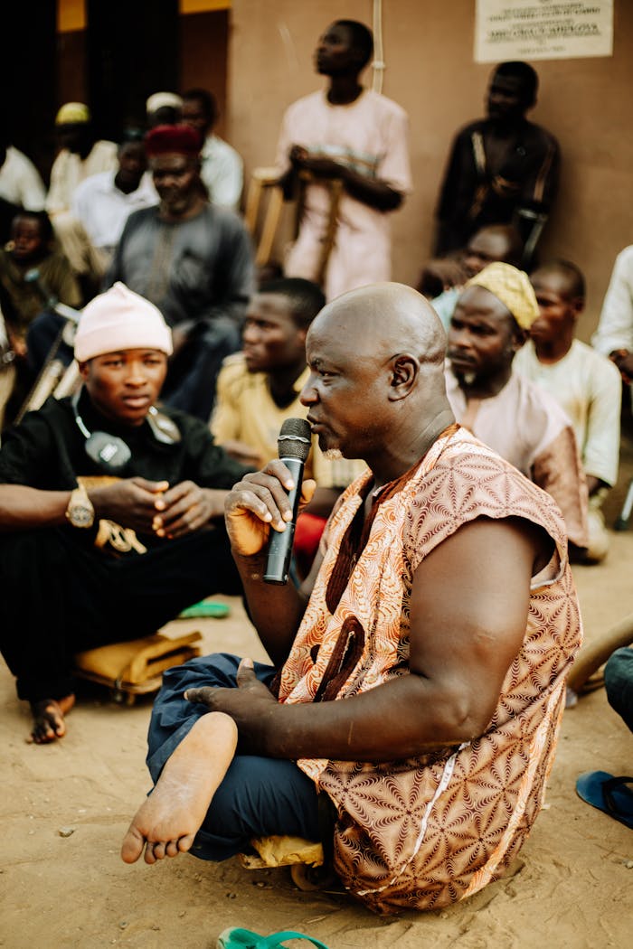 our-experience A community leader speaks to a group gathered outdoors, highlighting unity and tradition.