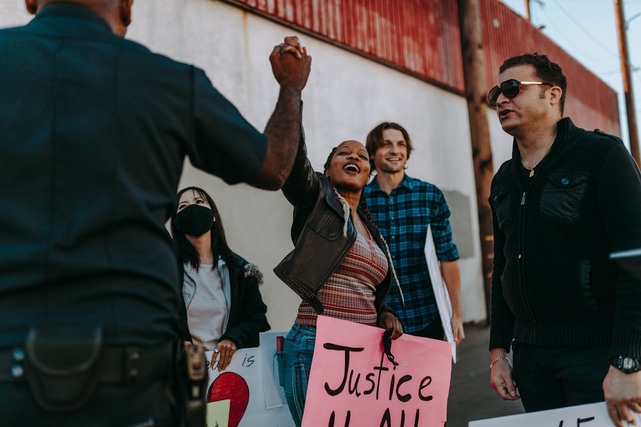 services-01 A diverse group rallies with signs at a peaceful protest outdoors. Positive interaction with police enhances community spirit.